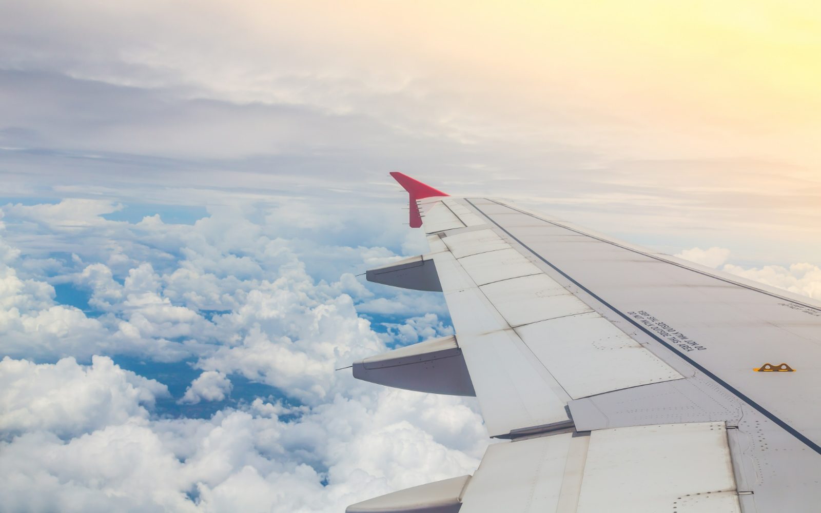 Clouds and an aircraft wing seen from a window
