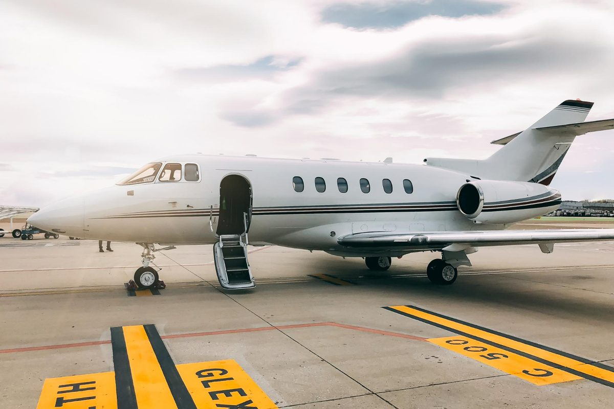A business jet parked on the apron with its steps down